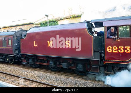 Camborne, Cornwall, Großbritannien, 28.. April 2022, die 84-jährige rote Dampflokomotive Duchess of Sutherland, 6233, machte sich heute früh auf den Weg von Cardiff nach Penzance. Sie hielt heute Abend um 7,37pm Uhr in Camborne an, zur Freude der Bahnbeobachter und Historiker gleichermaßen. Der vor dem Zweiten Weltkrieg gebaute Dampfzug fuhr durch Cornwall, als Teil einer "Tour" von London in alle Ecken des Landes.Quelle: Keith Larby/Alamy Live News Stockfoto