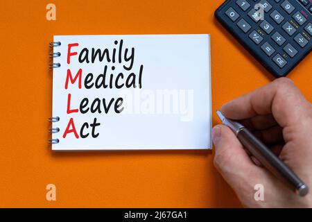 FMLA Familie medizinischen Urlaub Akt Symbol. Konzept Worte FMLA Familie medizinischen Urlaub handeln auf der Notiz auf schönen orangen Hintergrund. Arztzand. Rechner. Stockfoto