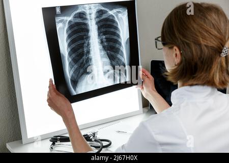 Pulmonologischer Therapeut, der eine Röntgenaufnahme der Lunge untersucht. Konzept der Gesundheitsversorgung und Krankenversicherung Stockfoto