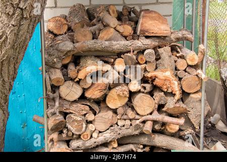 Brennholz Hintergrund - gehacktes Brennholz auf einem Stapel. Trockenes, gehacktes Brennholz in einem Haufen. Das Konzept der weltweiten Energiekrise. Stockfoto