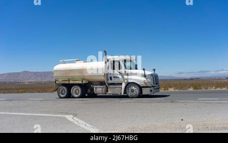 Apple Valley, CA, USA – 20. April 2022: Ein Weißwassertank-LKW fährt auf der State Route 18 in der Mojave-Wüste im Apple Valley, Kalifornien. Stockfoto
