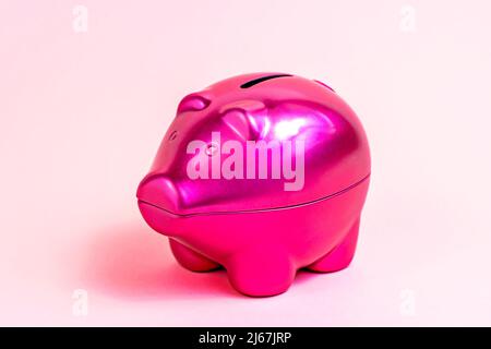 Leuchtend rosa Sparschwein für Münzen auf hellrosa Hintergrund. Stockfoto
