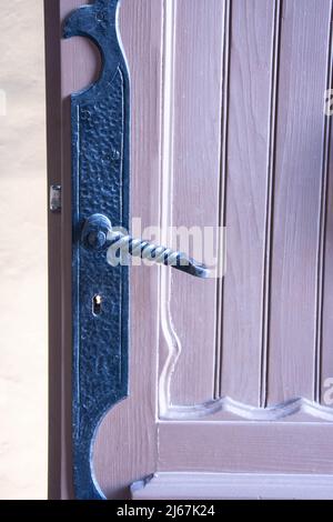 Vintage. Alte Holztür und rostiger Türknauf aus Eisen. Nahaufnahme, sehr hölzerne Tür mit Muster sehr alt abgenutzt mit eisernem Türgriff Stockfoto