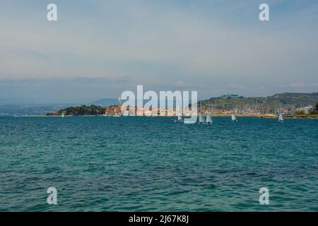 Die historische Stadt Izola an der Adriaküste Sloweniens. Eine Segelschule praktiziert im Vordergrund rechts Stockfoto