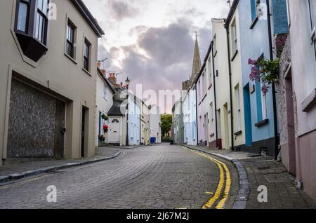 Leere gepflasterte Straße mit pastellfarbenen Häusern in der Abenddämmerung Stockfoto