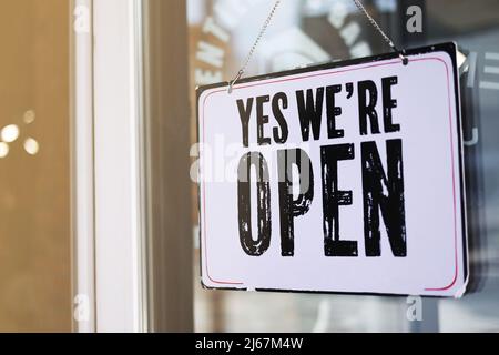 Nahaufnahme Foto von Schild yeas wir sind auf Tür auf unscharfen Hintergrund öffnen. Café, Salon, Restaurant bereit zu arbeiten. Förderung Geschäftskonzept Stockfoto