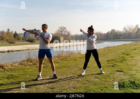 Zwei tolle und attraktive Fit-Freunde wärmen sich zusammen auf Stockfoto