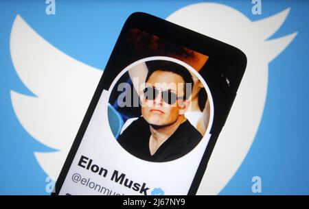 In dieser Abbildung ist der Twitter-Account von Elon Musk auf einem Smartphone-Bildschirm und im Hintergrund das Twitter-Logo zu sehen. Elon Musk erreicht eine Vereinbarung zum Kauf von Twitter Inc für $44 Milliarden, Berichten zufolge durch die Medien. Stockfoto