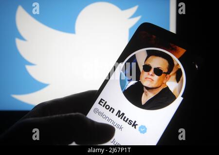 In dieser Abbildung ist der Twitter-Account von Elon Musk auf einem Smartphone-Bildschirm und im Hintergrund das Twitter-Logo zu sehen. Elon Musk erreicht eine Vereinbarung zum Kauf von Twitter Inc für $44 Milliarden, Berichten zufolge durch die Medien. (Foto von Pavlo Gonchar / SOPA Images/Sipa USA) Stockfoto