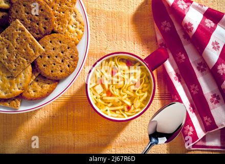 Hühnernudelsuppe mit Kräckern Stockfoto