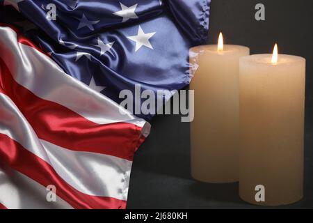 USA Flagge und brennende Kerzen auf schwarzem Hintergrund. Memorial Day Stockfoto