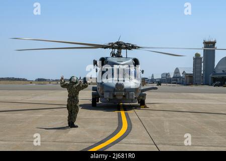 MISAWA, Japan (28. April 2022) – die Luftfahrtelektroniktechnikerin der Klasse 3., Pierina Toledo, die den „WARLORDS“ des Hubschrauber-Seestreikgeschwaders 51 zugewiesen wurde, tastet einen MH-60R, während er sich auf den Start von der Naval Air Facility (NAF) Misawa vorbereitet. NAF Misawa bietet Flug- und Bodenlogistik-Unterstützung und -Dienste für alle permanenten und vorübergehenden US-Marine- und US-Marine-Corps-Streitkräfte in Nordjapan. (USA Navy Foto von Mass Communication Specialist Seaman Unique Byrd) Stockfoto