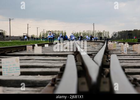 Auschwitz, Polen. 28. April 2022. Teilnehmer auf der Route des Marsches der Lebenden gesehen. Am Internationalen Holocaust-Gedenktag nehmen Teilnehmer aus verschiedenen Teilen der Welt am Marsch der Lebenden Teil. Der Marsch der Lebenden ist eine Hommage und ein Zeichen des Gedächtnisses für die Holocaust-Opfer. Die Teilnehmer des Marsches fahren gemeinsam über die drei Kilometer lange Strecke vom Tor Arbeit Macht frei im ehemaligen deutschen Lager Auschwitz I zum ehemaligen Standort Auschwitz II - Birkenau. Kredit: SOPA Images Limited/Alamy Live Nachrichten Stockfoto