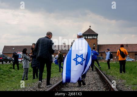 Auschwitz, Polen. 28. April 2022. Teilnehmer auf der Route des Marsches der Lebenden gesehen. Am Internationalen Holocaust-Gedenktag nehmen Teilnehmer aus verschiedenen Teilen der Welt am Marsch der Lebenden Teil. Der Marsch der Lebenden ist eine Hommage und ein Zeichen des Gedächtnisses für die Holocaust-Opfer. Die Teilnehmer des Marsches fahren gemeinsam über die drei Kilometer lange Strecke vom Tor Arbeit Macht frei im ehemaligen deutschen Lager Auschwitz I zum ehemaligen Standort Auschwitz II - Birkenau. Kredit: SOPA Images Limited/Alamy Live Nachrichten Stockfoto