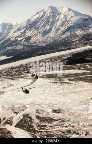 Die nationalen Wachmänner der Alaska Army mit dem 2-211. General Support Aviation Bataillon reisen vom Joint Base Elmendorf-Richardson nach Nome, Alaska, über UH-60L Black Hawk und CH-47 Chinook Hubschrauber vom 11. April 2022. Der Hubschrauber CH-47 wird die Flugcrews nach JBER zurückbringen, während die Hubschrauber der UH-60L Black Hawk in Nome bleiben, um Golf Company, Ablösung 1, 2-211. GSAB, bei Bedarf in diesem Frühjahr jährliche Schulungen und Unterstützung in River Watch durchzuführen. Sollte es in der Nähe zu erheblichen Überschwemmungen oder anderen Notfällen kommen, werden die Black Hawk-Hubschrauber wie vom Staat gefordert Unterstützung leisten. (Alaska Stockfoto