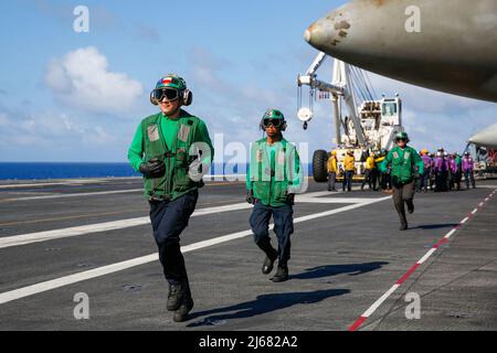 PHILIPPINISCHE SEEFAHRER (26. April 2022) laufen während der Flugdecksübungen an Bord des Flugzeugträgers USS Abraham Lincoln (CVN 72), um den Nozzleman zu entlasten. Die Abraham Lincoln Strike Group befindet sich im geplanten Einsatzgebiet der US-Flotte für 7., um die Interoperabilität durch Allianzen und Partnerschaften zu verbessern und gleichzeitig als reaktionsfähige Truppe zur Unterstützung einer freien und offenen Region im Indo-Pazifik-Raum zu dienen. (USA Navy Foto von Mass Communication Specialist Seaman Han Alexandra Puyu) Stockfoto