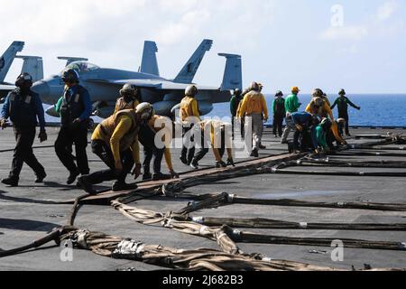 PHILIPPINISCHE SEEFAHRER (26. April 2022) haben während der Flugdecksübungen an Bord des Flugzeugträgers USS Abraham Lincoln (CVN 72) der Nimitz-Klasse eine Barrikade aufgestellt. Die Abraham Lincoln Strike Group befindet sich im geplanten Einsatzgebiet der US-Flotte für 7., um die Interoperabilität durch Allianzen und Partnerschaften zu verbessern und gleichzeitig als reaktionsfähige Truppe zur Unterstützung einer freien und offenen Region im Indo-Pazifik-Raum zu dienen. (USA Navy Foto von Mass Communication Specialist Seaman Kassandra Alanis) Stockfoto