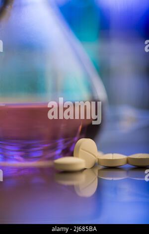 Hellgelbe Pillen aus dem Labor mit Laborflasche - Stock Foto Stockfoto