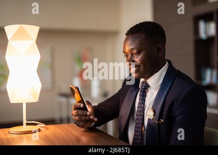 Porträt eines hübschen jungen afrikanischen Mannes, der nachts im Büro ist Stockfoto