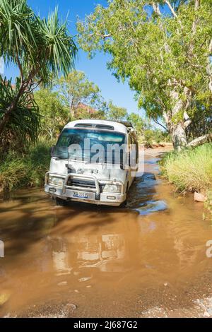 Off-Road Toyota Coaster Bus fährt durch einen Bach im Purnululu National Park oder Bungle Bungles, ein UNESCO-Weltkulturerbe in der Kimberley, Weste Stockfoto