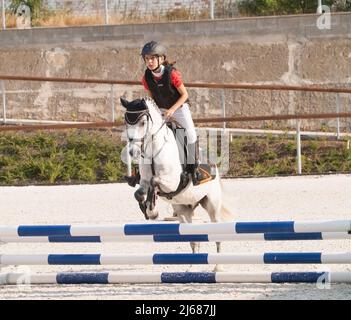 Mädchen mit Roan Pony auf Springprüfung Stockfoto