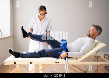 Physiotherapeut Überprüft Das Knie Des Patienten. Physiotherapie Und Schmerzen Stockfoto