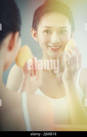 Die junge Frau im Spiegel Make-up Stockfoto