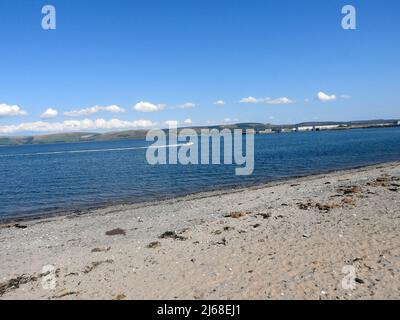 Loch Ryan, Schottland, ein Jet-Skifahrer mit Stranraer Pier und Bahnhof auf der rechten Seite Stockfoto