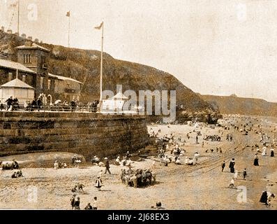 Whitby Yorkshire, England. Die alte Küstenwache auf der Battery Parade (jetzt ein Café) mit Urlaubern am Strand und Eselreiten im Vordergrund Stockfoto