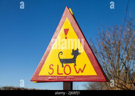 Ein selbstgemachtes Schild, das Autofahrer vor dem Überqueren von Katzen warnt Stockfoto