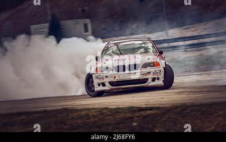 S17-04-2022 Riga, Lettland Hafentrollrad driftet. Verschwommenes Bild Diffusion Rennen Drift Auto mit viel Rauch von brennenden Reifen auf der Rennstrecke. Spor Stockfoto