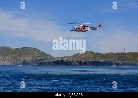 Vulcano, Sizilien, April 9, italienische Küstenwache während einer Übung auf der Insel Vulcano. Fokus und Detail auf dem gestickten Patch der italienischen Küstenwache auf 2022. AgustaWestland AW139 der italienischen Küstenwache. Stockfoto