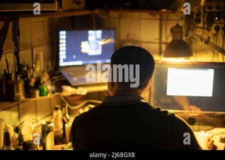 Hacker am Computer. Mann im Dunkeln. Silhouette einer Person, die im Internet arbeitet. Stockfoto