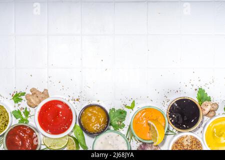 Auswahl an verschiedenen klassischen Saucen und Dips in Sauceboats. Mayonnaise, Ketchup, Tartare, Senf, Pesto, Saure Rahm, Grillsaucen mit Gewürzen, Stockfoto