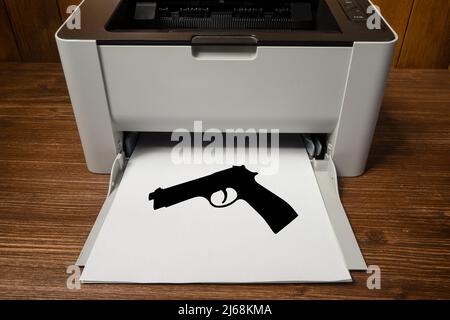 Eine Pistole, die auf ein Blatt Papier gedruckt wurde, das aus dem Drucker austritt Stockfoto