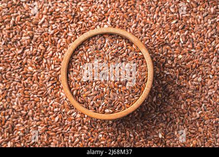 Leinsamen in einer Holzschale und auf dem Hintergrund. Quelle von Omega 3. Draufsicht. Stockfoto