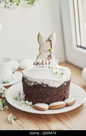 Feier und Feiertag. Osterkuchen mit Lebkuchen, hausgemachtem Kuchen, Eiern. Osterhase und blühende Zweige Postkarte. Stockfoto