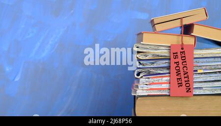 Stapel von Büchern, gefalteten Karten und Slogan Wissen ist Macht, Lernen, Bildung, zurück zur Schule Konzept, freie Kopie Raum, negative Technik Stockfoto