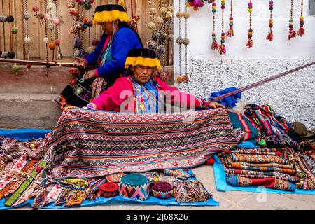 Indigene Frauen In Traditioneller Tracht Mit Der Traditionellen Methode Des Wabens Von Wolle In Der Stadt Pisac, Dem Heiligen Tal, Provinz Calca, Per Stockfoto