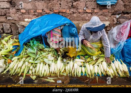 Lokale Frauen, Die Choclo (Mais) Im Regen Auf Einem Straßenmarkt Im Freien In Cusco, Provinz Cusco, Peru, Verkaufen. Stockfoto