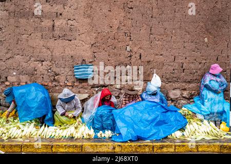 Lokale Frauen, Die Choclo (Mais) Im Regen Auf Einem Straßenmarkt Im Freien In Cusco, Provinz Cusco, Peru, Verkaufen. Stockfoto