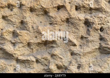 Raue Wand Putz Hintergrund Textur. Schmutzige Gebäudefassade einer Oberfläche. Stuckmaterialstruktur auf einer Fassade. Stockfoto