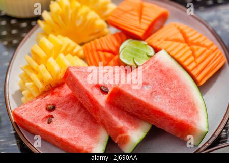 Teller mit schneidenden reifen frischen exotischen tropischen Früchten. Verschiedene saftige Rohkost Stockfoto