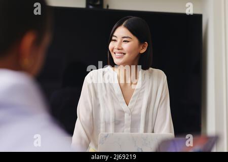 Porträt einer fröhlichen mittelerwachsenen chinesischen Geschäftsfrau, die in einem Geschäftstreffen selbstbewusst lächelt Stockfoto