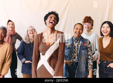 Internationaler Frauentag Porträt fröhlicher, multiethnischer Frauen im gemischten Alter, die lachen und lächeln Stockfoto