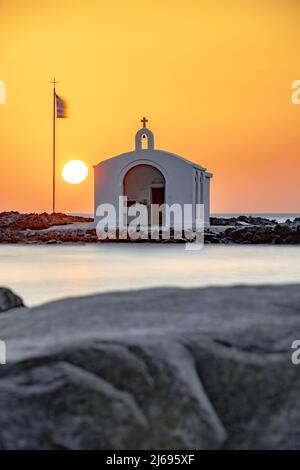 Die Sonne geht über der berühmten Agios Nikolaos Kirche und den Klippen, Georgioupolis, Kreta Insel, griechische Inseln, Griechenland Stockfoto