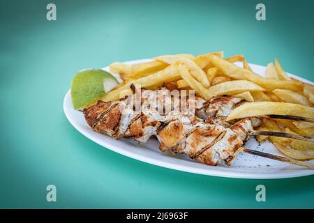 Souvlaki, beliebtes griechisches Essen, bestehend aus kleinen Fleischstücken, die auf einem Spieß gegrillt werden, serviert mit pommes frites, griechischen Inseln, Griechenland, Europa Stockfoto