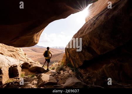 Mann, der die Aussicht in den Sandsteinschluchten genießt, Barranco de las Penitas, Fuerteventura, Kanarische Inseln, Spanien, Atlantik, Europa Stockfoto