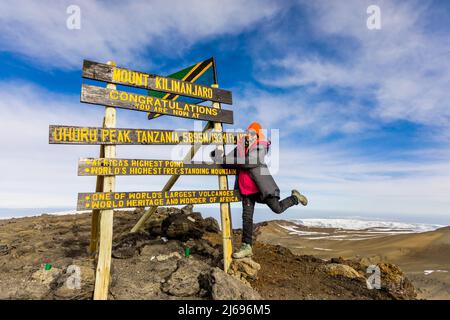 Die Frau war begeistert, als sie es zum Uhuru Peak auf dem Kilimandscharo, UNESCO-Weltkulturerbe, Tansania, Ostafrika, Afrika, geschafft hat Stockfoto