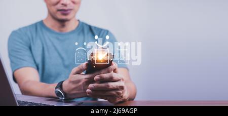 Customer Service Evaluation Konzept. Lächelnder asiatischer Mann verwendet ein Smartphone und er drückt Gesicht Emoticon Lächeln in Zufriedenheit auf virtuelle Berührung Stockfoto